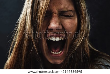 Shes reached the end of her rope. A young woman screaming uncontrollably while isolated on a black background. Royalty-Free Stock Photo #2149634595
