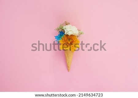 Anything looks good on a ice cream cone. Shot of a cone stuffed with flowers against a colorful background.