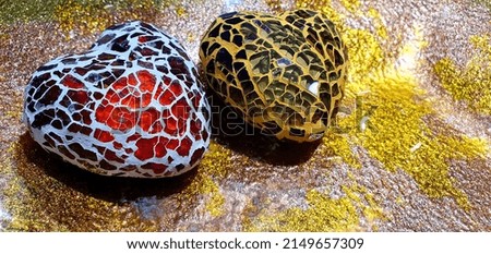 Two beautiful glass hearts on a golden glittering background. Beautiful two hearts for decoration. Love background. Hearts background. Hearts made of pieces of glass.