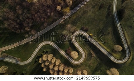 A winding bike path in a city park. Flight over the spring city park. Aerial photography.