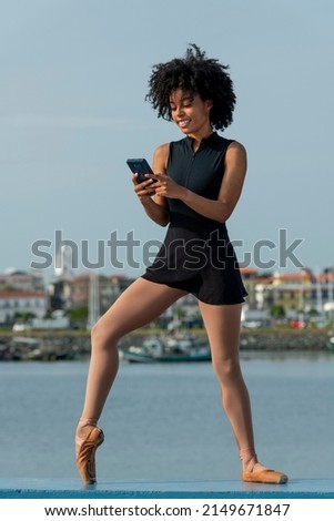 Woman in ballet dress with cell phone sending a text message, Panama, Central America