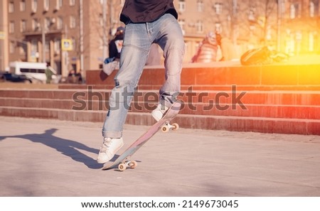 Man young skateboarder legs skateboarding skatepark on sunset. Concept tricks and jumping on skateboard.