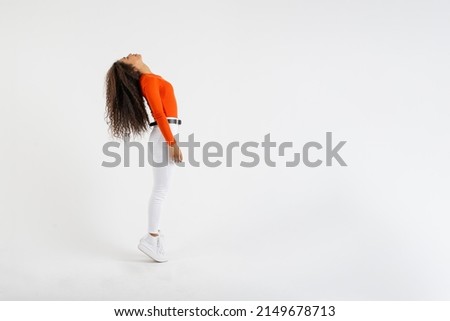 Young woman standing on tiptoe throwing her head back on white background