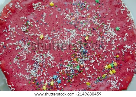 Homemade pink cake with colorful sprinkles close-up, flat lay