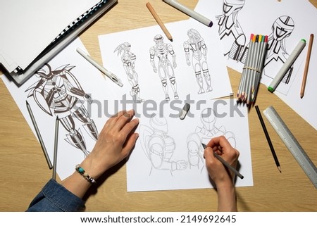 Concept art. The artist draws sketches of robots on paper. Character design for a video or animation game.