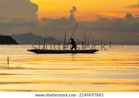 A fisherman is escorting a boat ashore in his boat at sunset, Life style of fisherman.