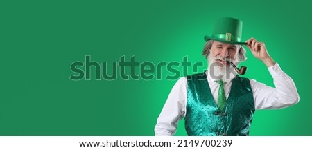 Senior man smoking pipe on green background with space for text. St. Patrick's Day celebration