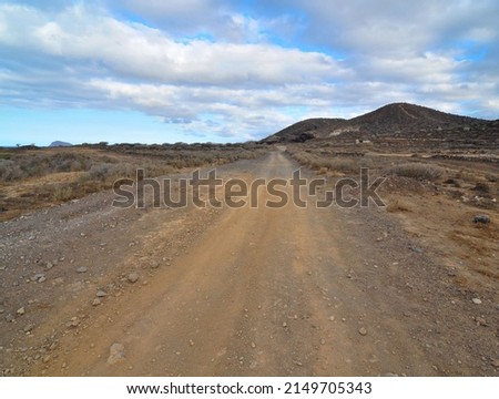 Sand and Rocks Road in the Desert on a Cloudy Sky