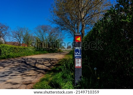 Hiking trail signs and equestrian route 28 in Molenplas nature reserve, dirt trails and green leafy trees in the background, sunny day with a blue sky in Stevensweert, South Limburg, Netherlands