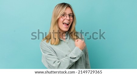 young pretty blonde woman feeling happy, positive and successful, motivated when facing a challenge or celebrating good results