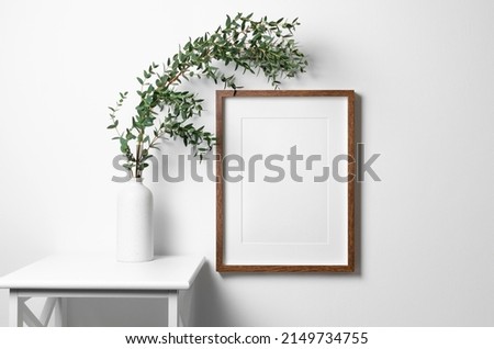 Wooden frame mockup on white wall minimalistic interior with copy space for artwork, photo, painting or print presentation.