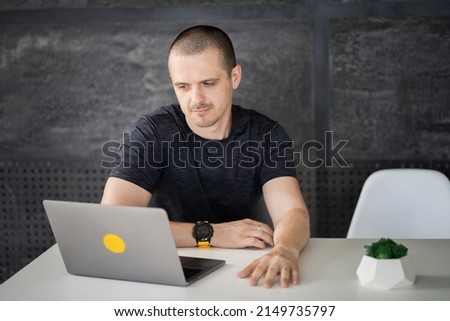 Happy man working on laptop in library or coworking office space
