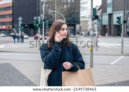 A young woman in the city on the street with a package, shopping concept.