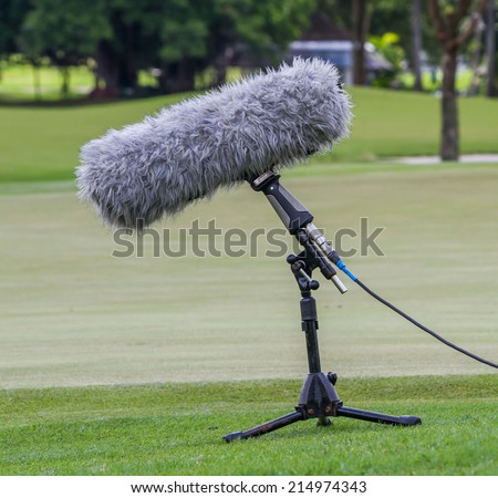 A large microphone boom with stand for TV or Radio situated at the grass.