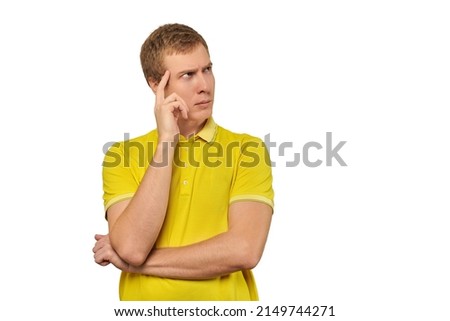 Thoughtful man in yellow T-shirt looking to right isolated on white background. Pensive young man thinking, guy putting hand to his head and looking to right, philosophical reflection concept
