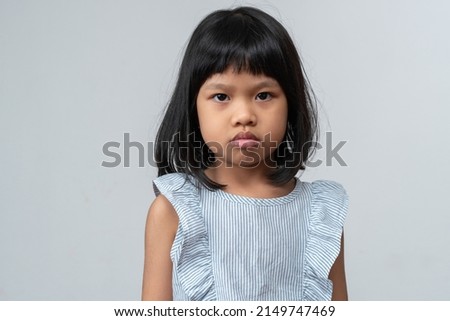 Portrait of Asian angry and sad little girl on white isolated background, The emotion of a child when tantrum and mad, expression grumpy emotion. Kid emotional control concept