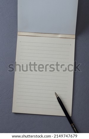 blank notebook on a grey base.