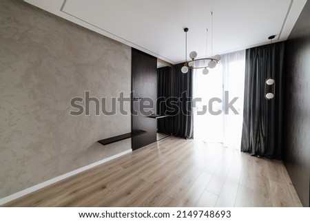 interior of a new large room with dark curtains and a floor