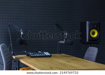 Podcast recording studio, with microphones and equalizer for recording online radio broadcasts, with black soundproof wall Royalty-Free Stock Photo #2149769733