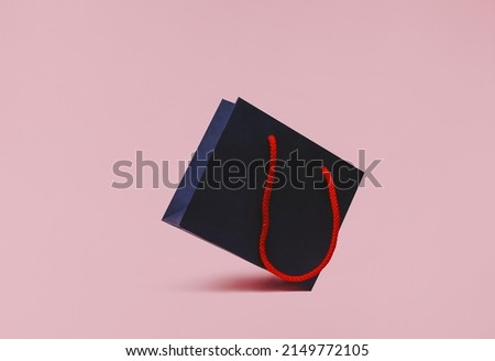 Shopping bag. Photo for banners with copy space. Dark blue paper bag on pink background