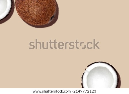 Coconuts. Top view photo with copy space. Full and halved coconuts on beige background