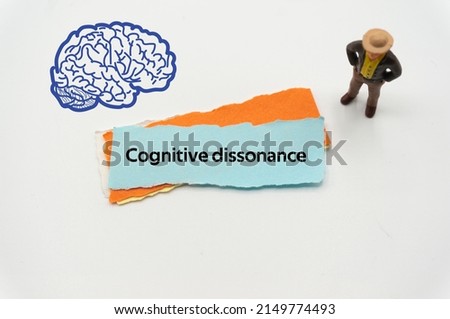 Cognitive dissonance.The word is written on a slip of colored paper. Psychological terms, psychologic words, Spiritual terminology. psychiatric research. Mental Health Buzzwords.