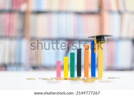 Graduate study abroad program for higher degree knowledge, education concept : Black graduation cap on increasing bar graph, depicting strong effort for students who study hard for a future career. Royalty-Free Stock Photo #2149777267