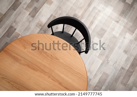 Round wooden table and black chair indoors, top view Royalty-Free Stock Photo #2149777745