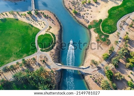 Bird eye view of the golf course with small boat crossing lagoons at tourists town El Gouna in The Red Sea, Egypt  Royalty-Free Stock Photo #2149781027