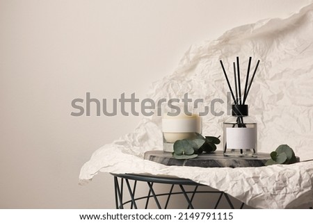 Aromatic reed air freshener, eucalyptus leaves and candle on table, space for text Royalty-Free Stock Photo #2149791115