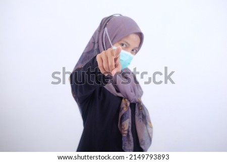 Muslim woman in mask with gesture showing finger in front of isolated white background