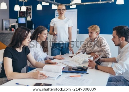 Young teacher standing near a study group.