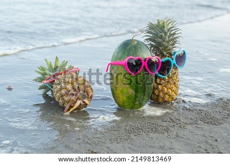 Pineapple and watermelon wearing sunglasses on the beach, Summer vacation beach concept, Selective focus.