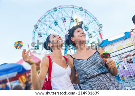 Happy Young Women at Luna Park Royalty-Free Stock Photo #214981639