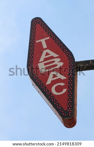 French white and red sign "tabac". In French, "tabac" means tobacco.