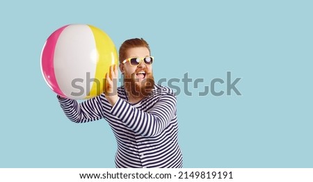 People, summer vacation, vacation and lifestyle. Banner.Cheerful funny guy in sunglasses playing with beach inflatable ball on pastel blue background. Bearded chubby man having fun near copy space.