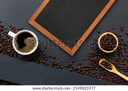 cup of coffee, wooden frame and bean on black wooden table background. top view. space for text. flay lay