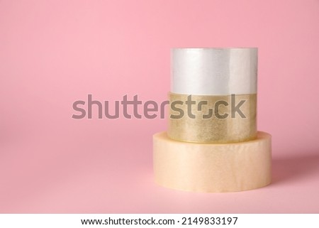 Three rolls of adhesive tape on pink background. Space for text Royalty-Free Stock Photo #2149833197