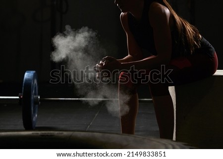 Unrecognizable woman sitting down chalking her hands.