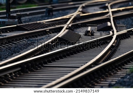 Railway Track with switches at a german station in Hagen with reflection on the blank steel rails and blurred vanishing point in the background. Lines and threshold structures with evening light.