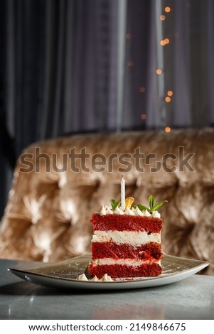 Pte on grey tabletop. Slice of delicious homemade red velvet cake with raspberry and chocolate. Copy space for text
