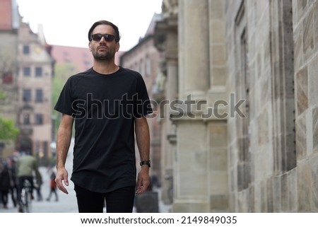 Black blank t-shirt on a hipster handsome male model with space for your logo or design in casual urban style