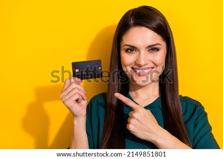 Photo of shiny pretty lady dressed green shirt pointing bank card isolated yellow color background