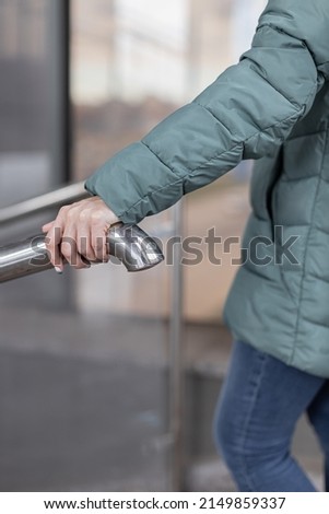 woman holding on to a bag as she goes down the stairs. High quality photo