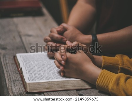 Close-up two christian read bible. Hands folded in prayer on a Holy Bible on wooden table. online group worship, World Day of Prayer, international day of prayer, hope, gratitude, thankful, trust Royalty-Free Stock Photo #2149859675