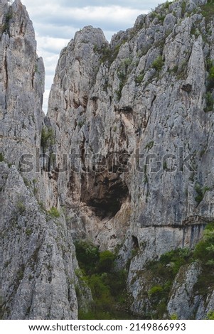 Mountain with cave inside it, silver vertical mountain picture