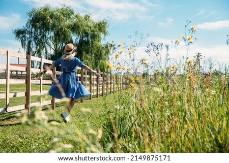 Domestic Travel, Local Travel, Summer Country Travel. Countryside Getaways, Country vacations, Farm Stays. Young woman in straw hat enjoys summer vacation at the farm in countryside Royalty-Free Stock Photo #2149875171