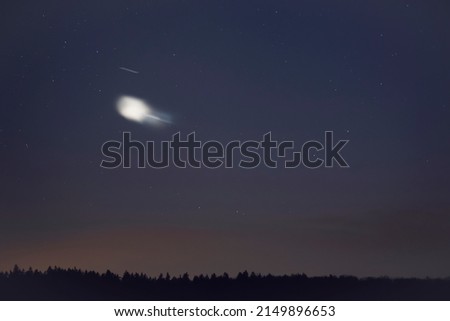 An unidentified flying object in the evening sky. Royalty-Free Stock Photo #2149896653