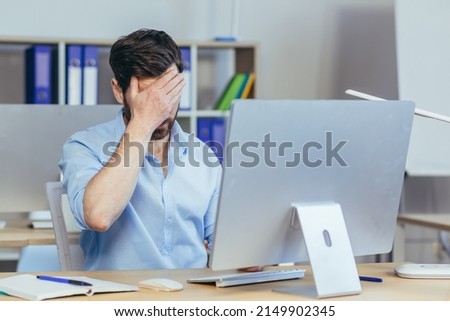Pensive and upset man working a day in a modern office, businessman holding his hand home longing depressed Royalty-Free Stock Photo #2149902345