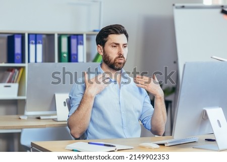 Hot in the office, a businessman in a shirt working in a bright modern office, waving his arms trying to freshen up Royalty-Free Stock Photo #2149902353